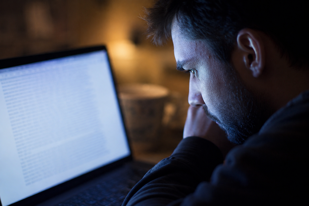 Man reading a confidently written AI response late at night on a laptop